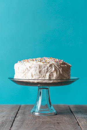 Téléchargez les photos : Gâteau d'anniversaire avec glaçage blanc et saupoudrer sur fond bleu. - en image libre de droit