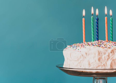 Téléchargez les photos : Gâteau d'anniversaire avec glaçage blanc et bougies sur fond bleu. - en image libre de droit