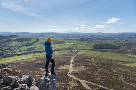 Foto de Caminante de pie sobre roca admirando el paisaje de montaña de mimbre - Imagen libre de derechos