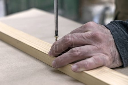 Foto de Un trabajador está montando una tabla de madera - Imagen libre de derechos
