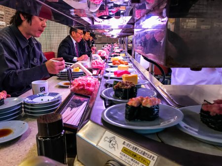 Photo for Sushi dispensing sliding bands in Japanese restaurant. - Royalty Free Image