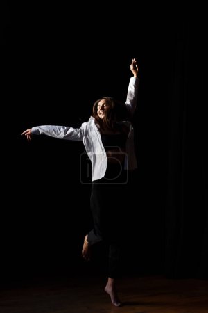 Téléchargez les photos : Actrice brune danse pieds nus dans la salle de répétition du théâtre - en image libre de droit
