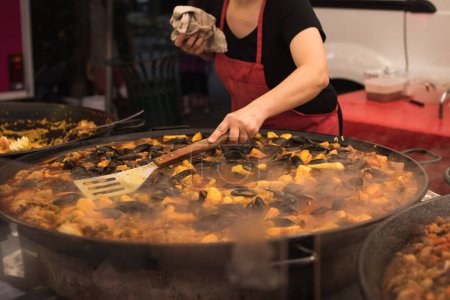 Photo for Woman serving traditional hot seafood stew in Provence, France - Royalty Free Image