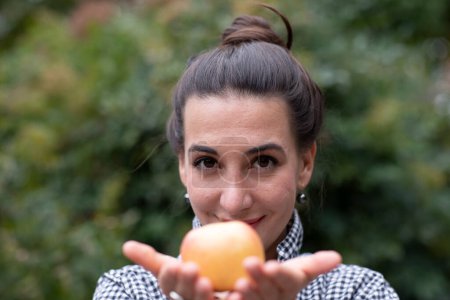 Téléchargez les photos : Femme avec pomme devant le visage - en image libre de droit