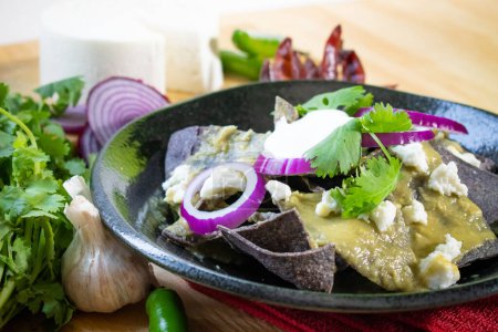 Exotic blue corn chilaquiles with green salsa and cream.