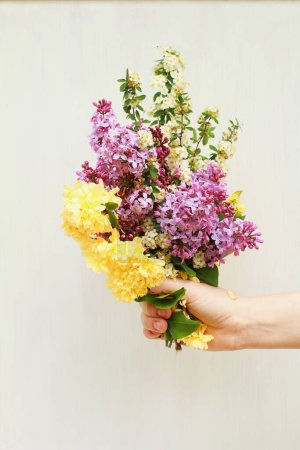 Photo for Hand holding bundle of Flowers Purple, Yellow, & White - Royalty Free Image