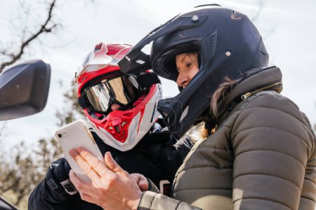 Photo for Two people looking at the route on the cell phone while riding a quad - Royalty Free Image