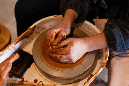 Photo for Two Womans molding shape to clay on pottery wheel - Royalty Free Image