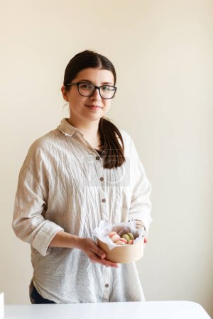 Photo for Girl confectioner entrepreneur holds a box with macaroons in her hands - Royalty Free Image