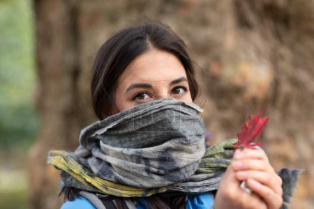 Téléchargez les photos : Jeune femme avec écharpe et feuille - en image libre de droit