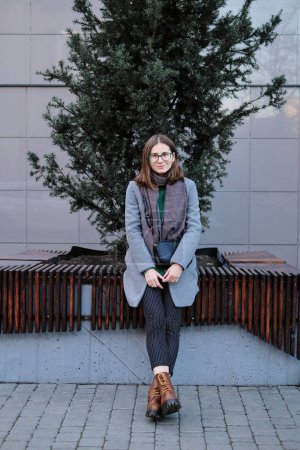 Téléchargez les photos : Femme aux cheveux bruns en lunettes portant un manteau et une écharpe en automne - en image libre de droit