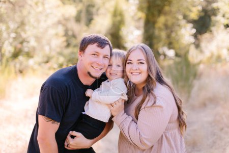 Photo for Happy family of 3, faces close together, outside - Royalty Free Image