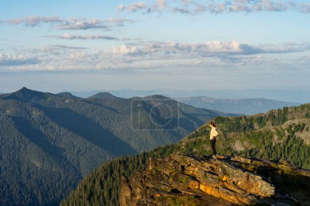 Téléchargez les photos : Randonneur se préparant pour une séance de yoga au lever du soleil au Mt Rainier à Wash. - en image libre de droit