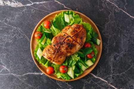 Téléchargez les photos : Rouleau de poulet grillé. Légumes frais dans une assiette - en image libre de droit