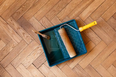 Photo for Brush and roller in container with varnish during varnishing parquet - Royalty Free Image