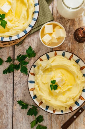 Téléchargez les photos : Purée de pommes de terre au beurre dans un bol sur une table en bois - en image libre de droit