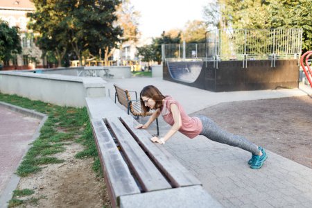 Téléchargez les photos : Jeune femme faisant du sport sur un terrain de sport en plein air en été - en image libre de droit