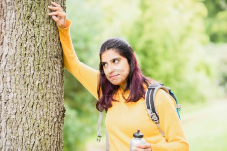 Téléchargez les photos : Jeune femme randonnée et debout près d'un arbre - en image libre de droit