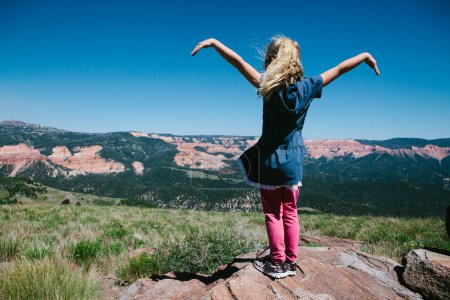 Téléchargez les photos : Petite fille surplombant la chaîne de montagnes et l'herbe et les montagnes - en image libre de droit