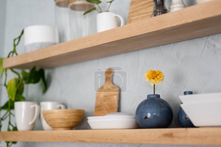 Foto de Jarrón azul y artículos de cocina en estante de madera moderna en la pared de yeso - Imagen libre de derechos