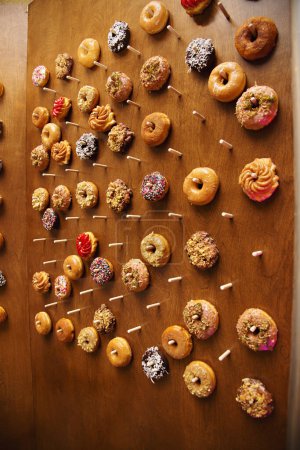 Assorted donuts displayed on wooden board.