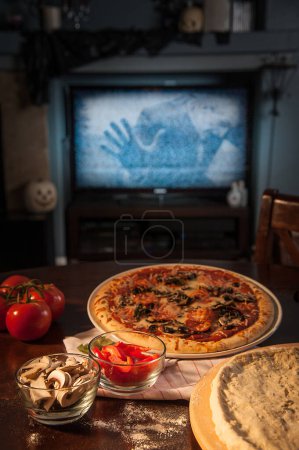 Spooky movie night with homemade pizza on the table