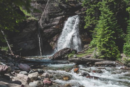 Waterfall cascading through a forested Montana landscape.