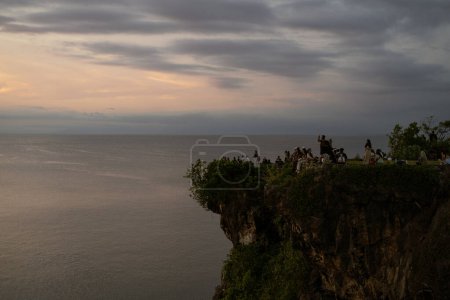 Distant view of people on cliff during sunset in Balangan, Bali