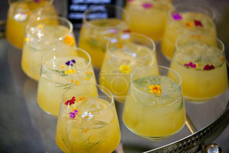 Photo for Colorful cocktails garnished with delicate edible flowers. - Royalty Free Image