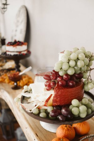 Foto de Bandeja de queso artesanal con vibrantes uvas y naranjas. - Imagen libre de derechos