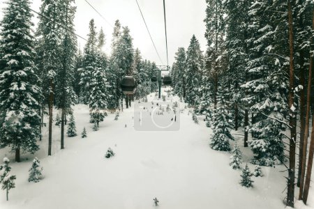 Skigondeln fahren durch einen ruhigen, verschneiten Wald.