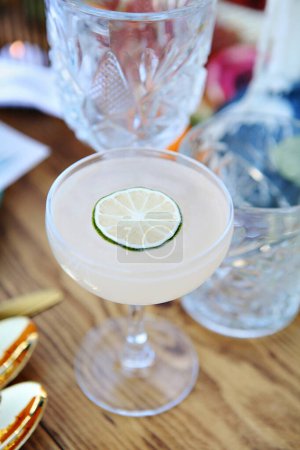 Elegant frothy cocktail topped with a thin lime wheel.