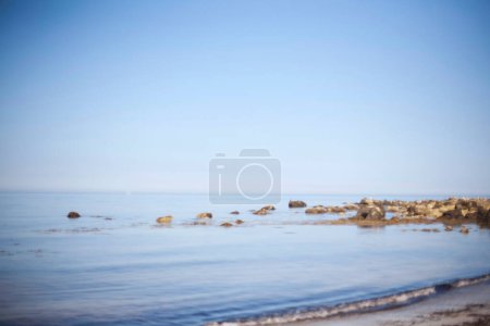 Photo for Soft-focus view of a tranquil sea meeting a clear, endless sky. - Royalty Free Image