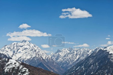 Montañas del Himalaya cubiertas de nieve con cielos azules y nubes hinchadas