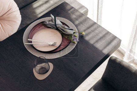 Foto de Elegant table setting with plates and flower on a black table - Imagen libre de derechos