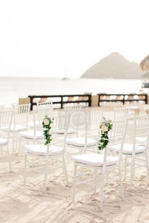 Photo for Elegant beach wedding chairs facing the ocean in St Lucia - Royalty Free Image