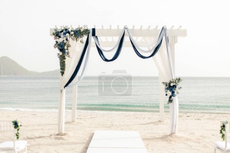 Arco de boda en la playa de Santa Lucía con fondo oceánico y decoración floral