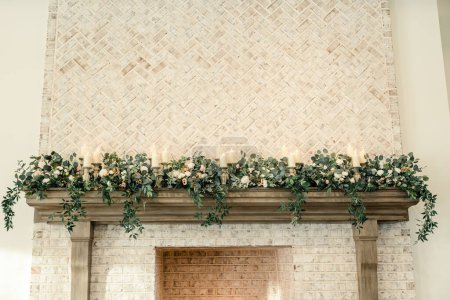 Floral and candle arrangement on a rustic fireplace mantel