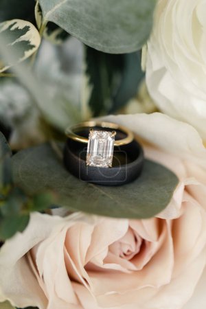 Téléchargez les photos : Bague en diamant taille émeraude et une alliance noire sur une rose - en image libre de droit