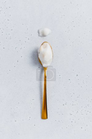 Single gold spoon full of milk foam