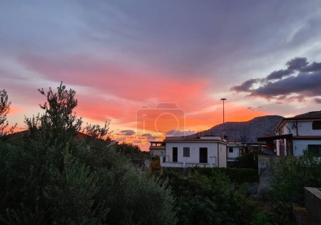 Photo for Evocative image of sunset with silhouette of houses and trees in the background - Royalty Free Image