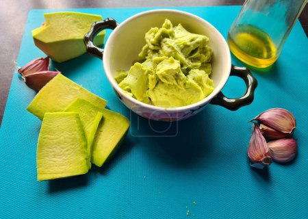 evocative image of homemade avocado cream prepared with garlic and oil ready to be spread on croutons as an aperitif