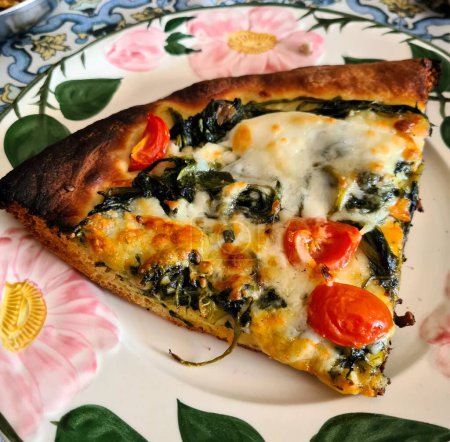 evokative Nahaufnahme Bild einer Scheibe weißer Pizza ohne Tomaten mit Brokkoli, in Scheiben geschnittenen Kirschtomaten und Mozzarella bereit zum Genießen