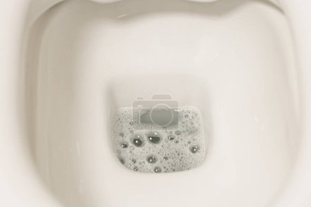 Téléchargez les photos : Une nouvelle approche de la tâche pas si glamour de nettoyer les toilettes, cette photo montre la précision et l'efficacité d'une brosse de toilette comme il nettoie la saleté et les taches. - en image libre de droit