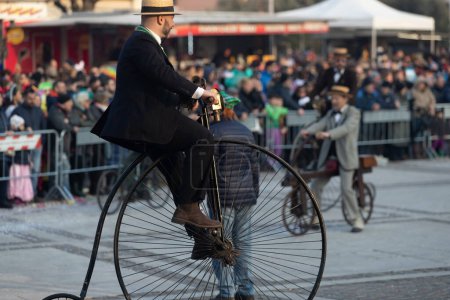 Foto de DOMIGLIARA, VERONA, ITALIA, FEBRERO, 2023: Diversión Bicicleta Clásica: Celebrante del Carnaval da una vuelta en un penique - Imagen libre de derechos