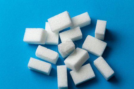 Téléchargez les photos : Cubes de sucre blanc sur fond bleu - en image libre de droit