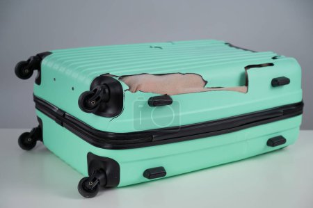 Téléchargez les photos : Valise endommagée à la menthe sur fond blanc - en image libre de droit