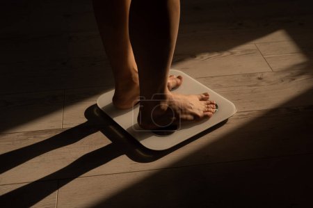 Foto de Primer plano de las piernas femeninas en balanzas electrónicas - Imagen libre de derechos