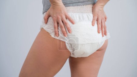 Rear view of a woman in adult diapers. Incontinence problem