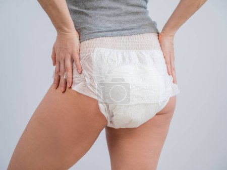 Rear view of a woman in adult diapers. Incontinence problem